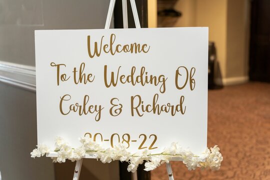 Wedding sign featuring ornate hand-lettering reading 'Welcome To The Wedding Of Carly & Richard"