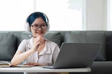 Happy young woman teenage wearing headphones writing note. student online learning class study online video call zoom teacher with laptop and book