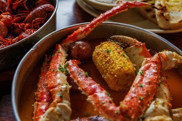 Closeup of A Cajun family-sized meal with boiled crawfish and jumbo crab legs.