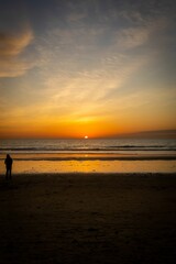 Fototapeta premium Person's silhouette on the beach at sunset.