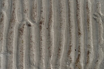 Closeup shot of lines in the wet sand on the beach.