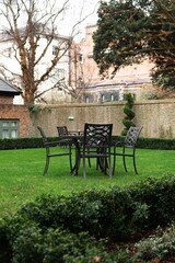 Vibrant outdoor dining setup consisting of a small round table and chairs on a lush green lawn.
