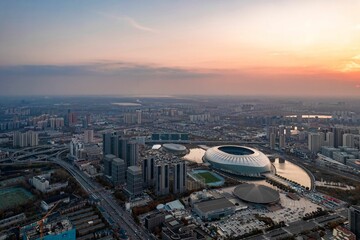 Aerial shot of Tianjin TV Tower and Water Park Complex near water in China at sunset
