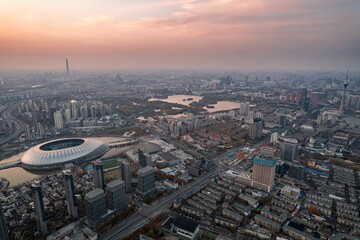Aerial shot of Tianjin TV Tower and Water Park Complex near water in China at sunset