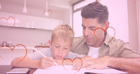 Image of hearts falling over caucasian man and his son doing homework