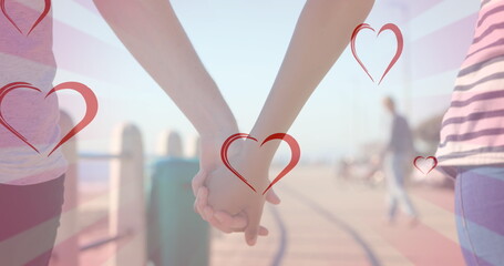 Image of hearts falling over diverse couple holding hands