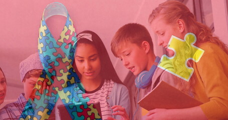 Image of colorful puzzle and ribbon over diverse children using tablet