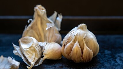 Closeup of Garlic bulb with individual garlic cloves from organic cultivation with a dark background