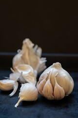 Closeup of Garlic bulb with individual garlic cloves from organic cultivation with a dark background