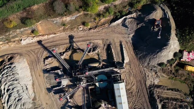 Bird's eye view over a quarry plantation and machines and tractors digging the ground