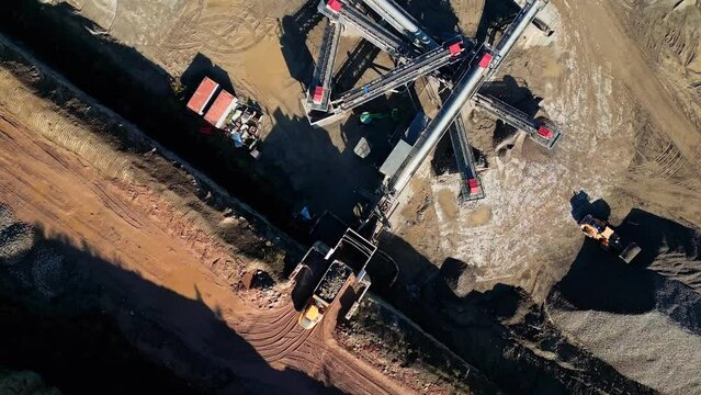 Bird's eye view over a quarry plantation and cranes and tractors digging the ground in the summer