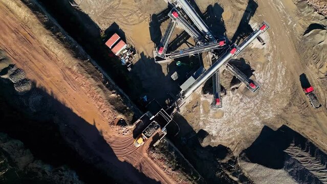 Bird's eye view over a quarry plantation with cranes and tractors digging the ground in the summer