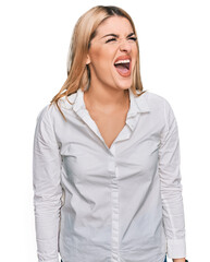 Young caucasian woman wearing casual clothes angry and mad screaming frustrated and furious,...