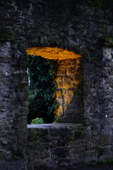 Von hinten beleuchtetes Fenster in einer alten Burgmauer.