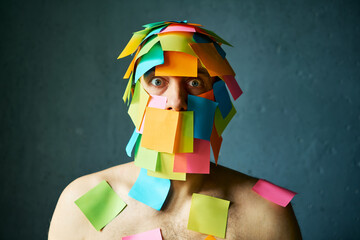 Shocked amazed man with colorful sticky notes all over his face over gray background - 767959997