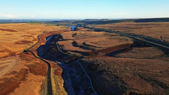 Aerial View of Saddleworth Moor, and motorway the M62  Windy Hill with blue sky on the horizon