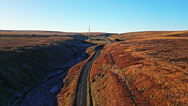 Aerial View of Saddleworth Moor, and motorway the M62  Windy Hill and Lake with blue sky horizon