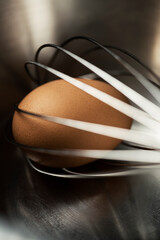 Brown egg with a whisk