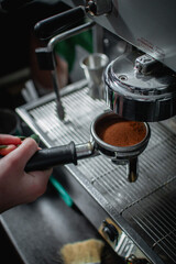 barista making coffee in a coffee machine