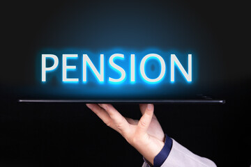 Man hand holds a tablet over which a neon text is written, the word PENSION. Business concept.