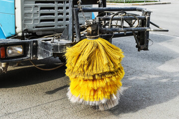 large yellow brush for cleaning city streets on street sweeper