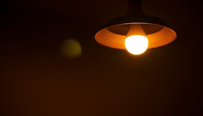 Closeup of a vintage light bulb illuminating a dark room