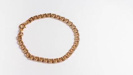 Round gold chain bracelet on a white surface