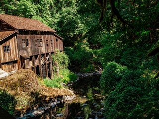 Closeup of An aged Gristmill in a picturesque rural setting surrounded by lush green on a sunny day