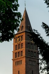 Fototapeta na wymiar Vertical of a brick clock tower at golden hour