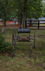 Antique wooden horse-drawn carriage on a grassy field in New England