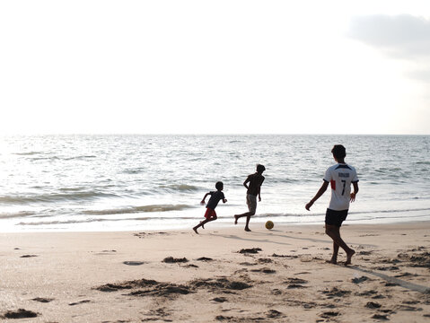 Boys and Kids playing football on the beach
