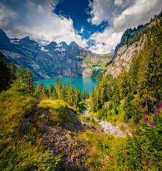 Superb summer view of unique lake - Oeschinen (Oeschinensee), UNESCO World Heritage Site. Nice outdoor scene in Bernese Oberland Alps, Switzerland, Europe. Beauty of nature concept background..