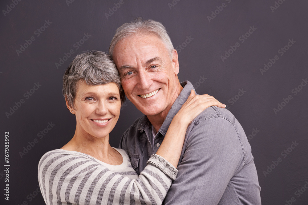 Poster Portrait, hug and senior couple with love, retirement and romance on grey studio background. Anniversary, face and old man with mature woman or embrace with relationship, marriage or bonding together