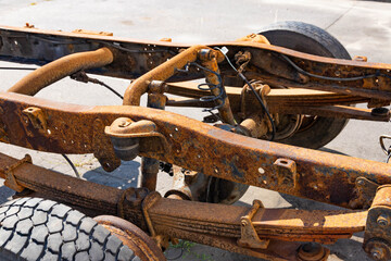 Old rusty car frame, shock absorber, truck wheel.