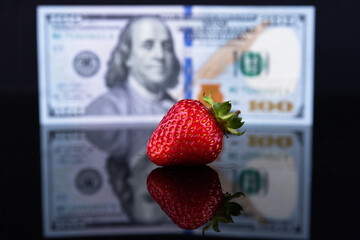 Red strawberries on a background of one hundred US dollars. Business concept. Sale of strawberries....