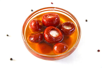 Red cherry peppers stuffed with cheese, in oil isolated on white background with pepper, top view. Healthy food. Great snack.