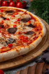 Meat pizza on a grey table.