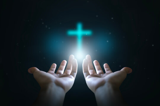 Easter concept, Open hands  holding a glowing cross , symbol of Christian faith.