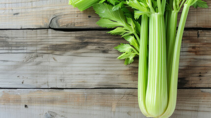Celery stalks with fresh leaves on a rustic wooden table.