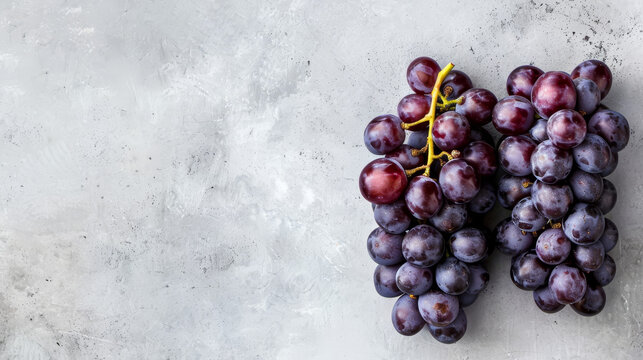 Two bunches of grapes on a grey textured background.