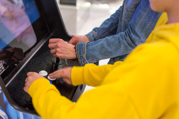 Detail on hands playing with joystick on old vintage arcade game in a dark room for playing video games