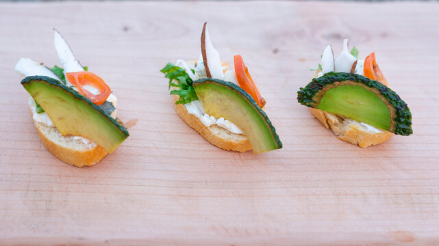 Finger food, bruschetti with salad, cheese , avocado and coconut.