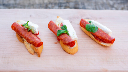 Finger food, bruschettas with salad, cheese , bacon , cucumber and cherry tomato.