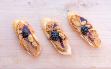Finger food, bruschettas with peanut butter and blackberry.