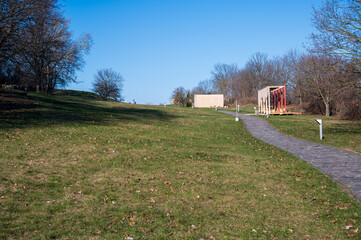 Stone path in meadow with trees nearby. Autumn.