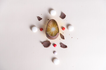 Easter egg in the center of a cross formed by sweet candies, celebration, Easter