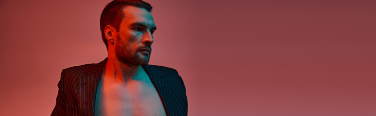 banner of man with bare chest posing in stylish pinstripe suit in studio with red and blue light