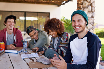 Friends, group and outdoor lunch or students together on backyard patio for bonding, notes or connection. Men, women and smile with beverages at table for community gathering, communication or snack