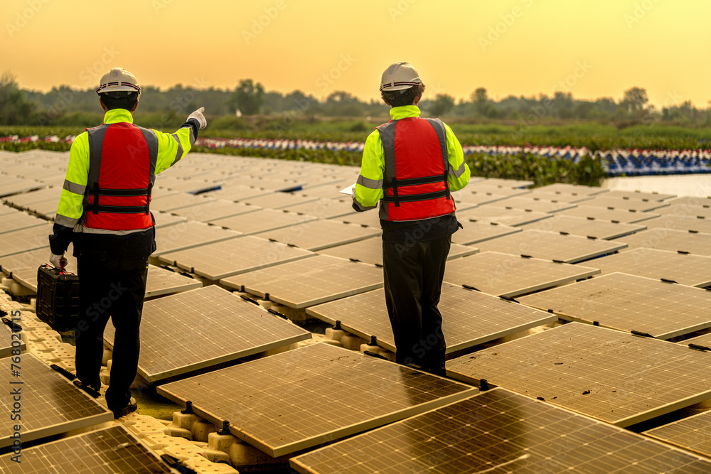 Wall mural male workers repair floating solar panels on water lake. engineers construct on site floating solar 