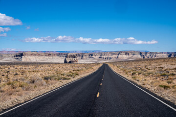 Road leading down to Lake Powell, Arizona. Lonely desert road with blue sky